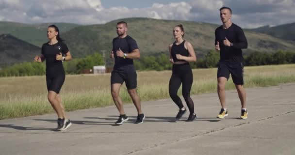 Multiethnische Gruppe von Athleten, die gemeinsam auf einer panoramischen Landstraße laufen. Vielfältiges Jogger-Team beim Morgentraining. — Stockvideo