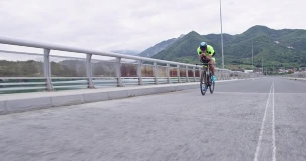 Triatlo atleta andar de bicicleta na estrada curvilínea país — Vídeo de Stock
