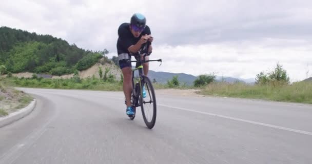 Triathlon desportista atleta ciclista equitação bicicleta de corrida profissional. Vestindo sportswear preto. — Vídeo de Stock