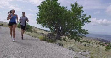 Spor yapan bir çiftin sabah dışarıda koşarkenki yavaş çekim görüntüleri, doğa tecrübeleri. Sağlıklı yaşam tarzı kavramı.