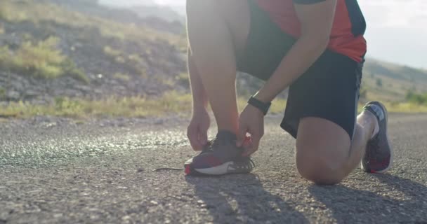 Close up shot. Man hands tie the laces on sports shoe. — Wideo stockowe