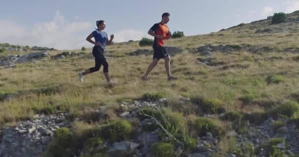 Seguimiento de la toma de cámara lenta de la pareja deportiva corriendo al aire libre en la mañana, la experiencia de trail running en la naturaleza. concepto de estilo de vida saludable. — Vídeos de Stock