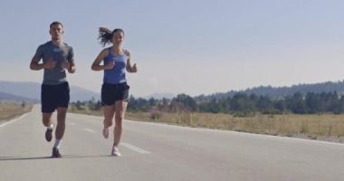 Sportif bir çift sabah dışarıda koşuyor, doğada iz sürme deneyimi var. Sağlıklı yaşam tarzı kavramı. Yüksek kaliteli görüntüler. Seçici odaklanma. Yavaş çekim takip ediliyor..