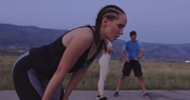 Çok ırklı bir grup sporcu yoğun idmandan sonra gece koşularından sonra dinleniyor. Yüksek kaliteli görüntüler. Yavaş çekim.