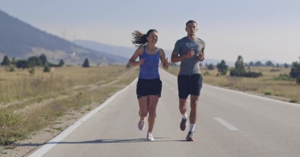 午前中に屋外でスポーティなカップルジョギング 自然の中でトレイルランニングの経験 健康的なライフスタイルのコンセプト 高品質の映像 選択的フォーカス スローモーション撮影 — ストック動画