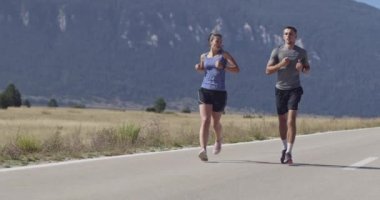 Sportif bir çift sabah dışarıda koşuyor, doğada iz sürme deneyimi var. Sağlıklı yaşam tarzı kavramı. Yüksek kaliteli görüntüler. Seçici odaklanma. Yavaş çekim takip ediliyor..