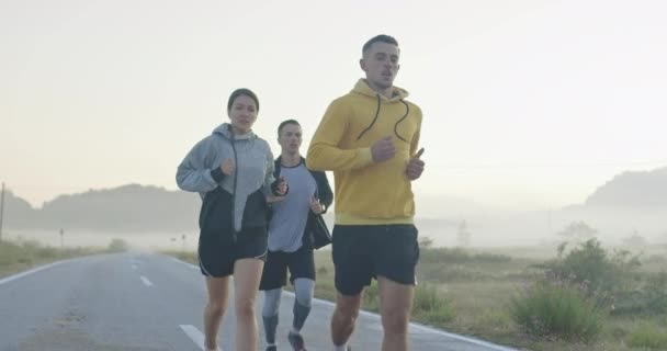多种族的运动员在全景乡间道路上共同跑步 不同的慢跑队在早上的训练 高质量的镜头 慢动作跟踪镜头 有选择的重点 — 图库视频影像