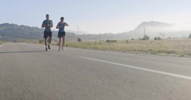Sportif bir çift sabah dışarıda koşuyor, doğada iz sürme deneyimi var. Sağlıklı yaşam tarzı kavramı. Yüksek kaliteli görüntüler. Seçici odaklanma. Yavaş çekim takip ediliyor..