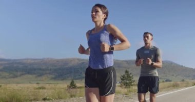 Sportif bir çift sabah dışarıda koşuyor, doğada iz sürme deneyimi var. Sağlıklı yaşam tarzı kavramı. Yüksek kaliteli görüntüler. Seçici odaklanma. Yavaş çekim takip ediliyor..