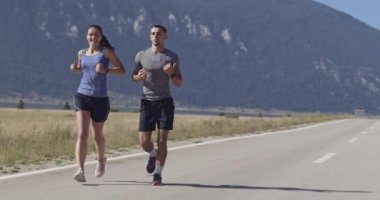 Sportif bir çift sabah dışarıda koşuyor, doğada iz sürme deneyimi var. Sağlıklı yaşam tarzı kavramı. Yüksek kaliteli görüntüler. Seçici odaklanma. Yavaş çekim takip ediliyor..