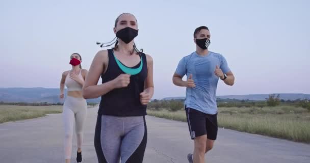 一群戴着医疗面罩的运动员在一场大流行病期间在路上奔跑 运动和验尸官 Covid 健康概念 社会疏离 慢动作有选择的重点 — 图库视频影像