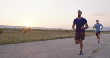 Dayanıklılık içinde yolda koşanlar güzel bir manzarada açık havada koşarlar. Yüksek kaliteli görüntüler