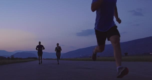 パノラマの田舎道で一緒に実行している選手の多民族グループ 朝のトレーニングでジョギングの多様なチーム 高品質の映像 トラッキングショットスローモーション — ストック動画