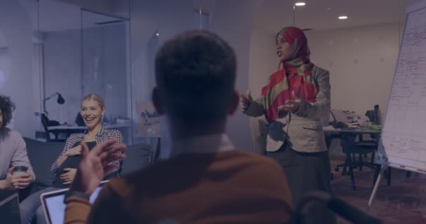 現代的なオープンスペースの同僚のオフィスでイスラム教徒の女性がチームにプレゼンテーションを行います 創造的なスタートアップオフィスで中東アラブのビジネス女性 チームミーティングの車椅子の障害者事業者 — ストック動画