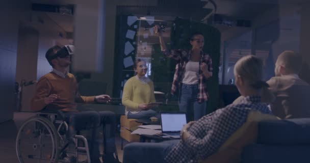 仮想現実ゴーグルとドローンシミュレーションを使用してチームミーティングで現代のオープンスペースの同僚のオフィスで仕事で車椅子で障害者のビジネスマン スタートアップビジネスにおける効果的なチームワーク — ストック動画
