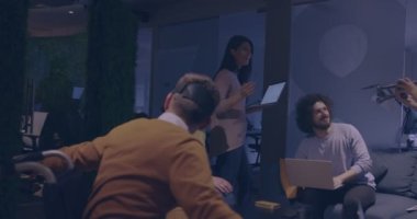 Modern açık uzay ofisinde çalışan engelli bir iş adamı sanal gerçeklik gözlüğü ve İHA simülasyonu kullanarak takım toplantısı yapıyor. Girişim işinde etkin takım çalışması.