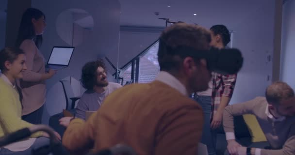 Disabled businessman in a wheelchair at work in modern open space coworking office on team meeting using virtual reality goggles and drone simulation — Stock Video