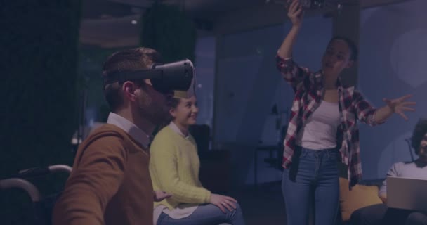 Інвалідний бізнесмен у інвалідному візку на роботі в сучасному офісі коворкінгу відкритого космосу на командній зустрічі з використанням окулярів віртуальної реальності та симуляції безпілотника — стокове відео