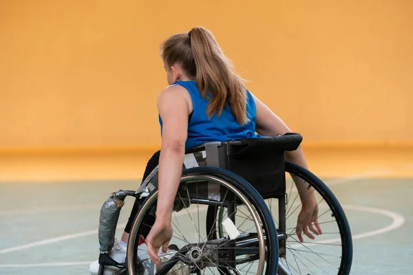 Een jonge vrouw die rolstoelbasketbal speelt in een professioneel team. Gendergelijkheid, het concept sport met een handicap. — Stockfoto