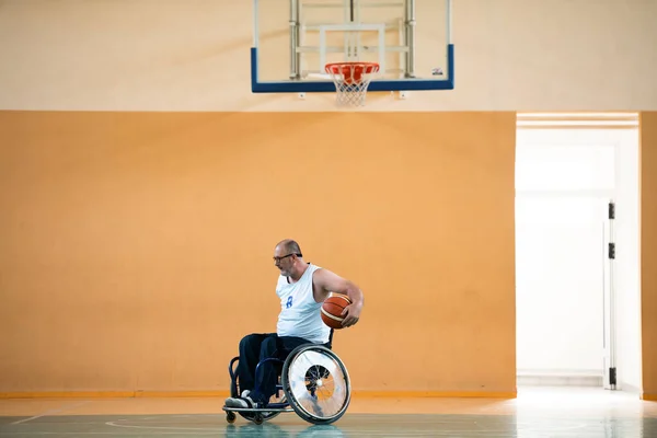 Een oorlog ongeldig in een rolstoel treinen met een bal op een basketbalclub in opleiding met professionele sportuitrusting voor gehandicapten. sport voor mensen met een handicap — Stockfoto