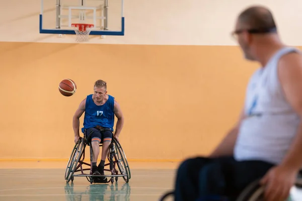 Gehandicapten oorlogsveteranen in rolstoelen met professionele apparatuur basketbal wedstrijd spelen in de gang.het concept van sport met een handicap — Stockfoto