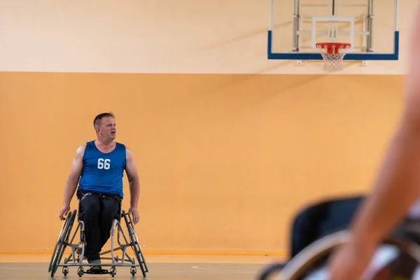 Uma foto de um veterano de guerra jogando basquete com uma equipe em uma arena esportiva moderna. O conceito de esporte para pessoas com deficiência — Fotografia de Stock