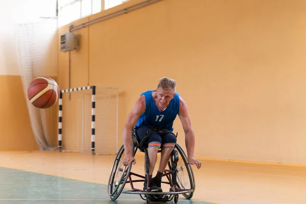 장애인 참전 용사들 이 장애 인을 위한 프로 스포츠 장비를 가지고 농구 코트에서 농구를 하고 있는 모습 — 스톡 사진