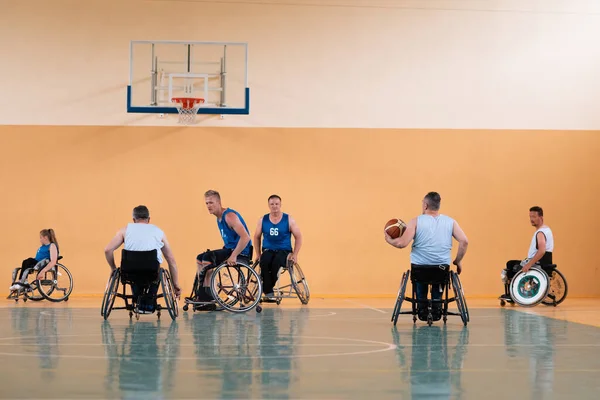 Gehandicapten Oorlog veteranen gemengd ras tegengestelde basketbalteams in rolstoelen gefotografeerd in actie tijdens het spelen van een belangrijke wedstrijd in een moderne hal. — Stockfoto