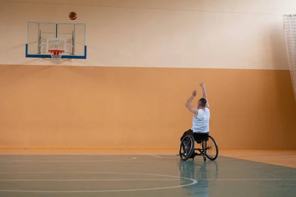 Een foto van een oorlogsveteraan die basketbal speelt met een team in een moderne sportarena. Het concept sport voor mensen met een handicap — Stockfoto