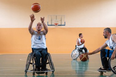 Modern spor sahasında bir takımla basketbol oynayan bir savaş gazisinin fotoğrafı. Engelliler için spor kavramı