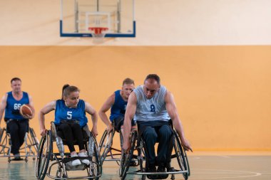 Engelli savaş gazileri, tekerlekli sandalyedeki karşı ırk basketbol takımlarını modern bir salonda önemli bir maç yaparken çektiler.. 