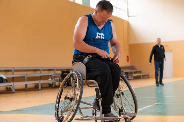 Um jogador de basquete deficiente se prepara para um jogo enquanto está sentado em uma cadeira de roda.Preparativos para um jogo de basquete profissional. o conceito de desporto com deficiência — Fotografia de Stock