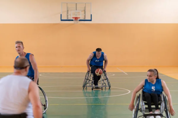 handicapped war veterans in wheelchairs with professional equipment play basketball match in the hall.the concept of sports with disabilities