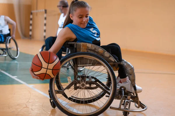 Eine junge Frau spielt Rollstuhlbasketball in einem Profiteam. Gleichberechtigung der Geschlechter, das Konzept des Behindertensports. — Stockfoto