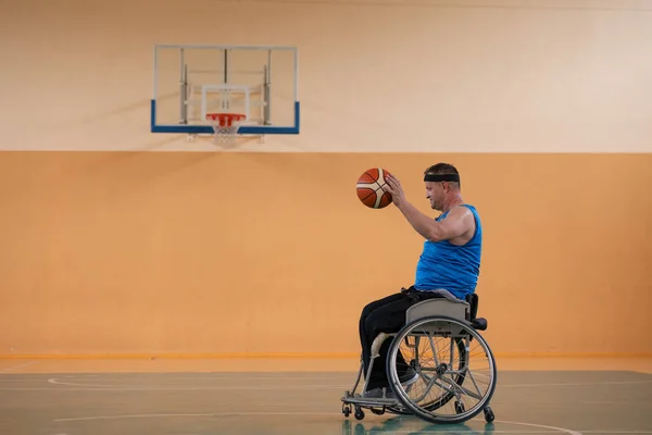 Uma foto de um veterano de guerra jogando basquete com uma equipe em uma arena esportiva moderna. O conceito de esporte para pessoas com deficiência — Fotografia de Stock