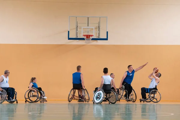 Veteranos de Disabled War se oponen a los equipos de baloncesto en sillas de ruedas fotografiados en acción mientras juegan un partido importante en una sala moderna. — Foto de Stock