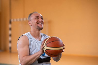 Modern spor sahasında bir takımla basketbol oynayan bir savaş gazisinin fotoğrafı. Engelliler için spor kavramı