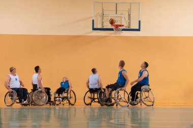 Sakat savaş gazileri basketbol sahasında basketbol oynarken engelliler için profesyonel spor ekipmanları kullanıyorlar.