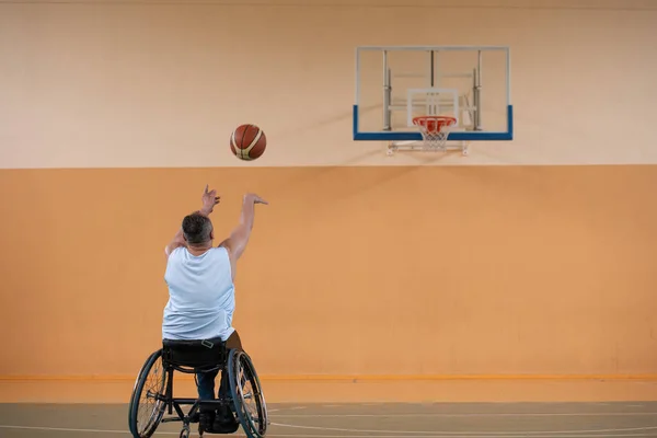 Uma foto de um veterano de guerra jogando basquete com uma equipe em uma arena esportiva moderna. O conceito de esporte para pessoas com deficiência — Fotografia de Stock