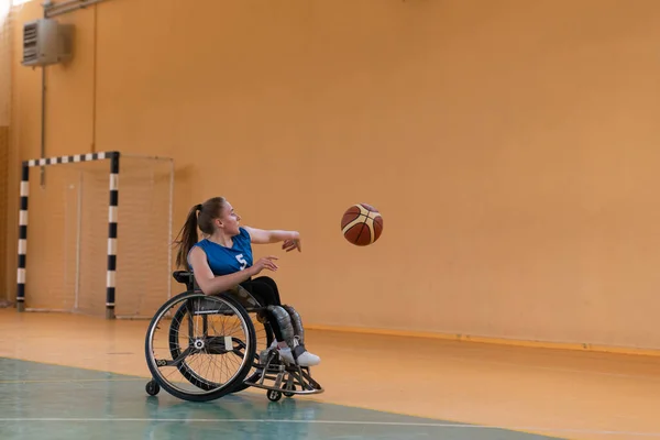 Eine junge Frau spielt Rollstuhlbasketball in einem Profiteam. Gleichberechtigung der Geschlechter, das Konzept des Behindertensports. — Stockfoto