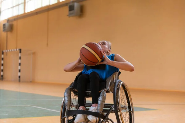Una joven que juega baloncesto en silla de ruedas en un equipo profesional. Igualdad de género, el concepto de deporte con discapacidad. — Foto de Stock