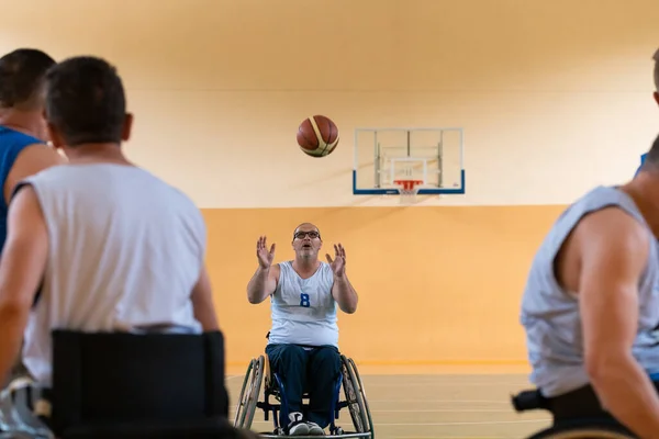 Veteranos de guerra deficientes em ação enquanto joga basquete em uma quadra de basquete com equipamentos esportivos profissionais para deficientes — Fotografia de Stock