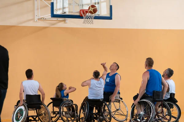 Gehandicapte oorlogsveteranen in actie tijdens het basketballen op een basketbalveld met professionele sportuitrusting voor gehandicapten — Stockfoto