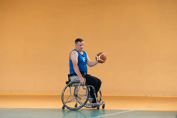 Een oorlog ongeldig in een rolstoel treinen met een bal op een basketbalclub in opleiding met professionele sportuitrusting voor gehandicapten. sport voor mensen met een handicap — Stockfoto