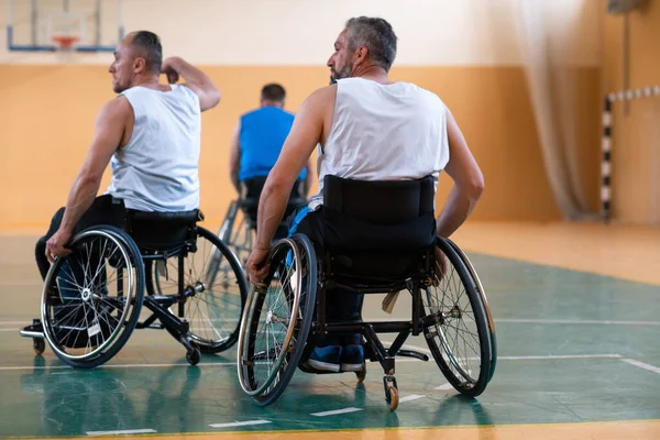 Gehandicapten oorlogsveteranen in rolstoelen met professionele apparatuur basketbal wedstrijd spelen in de gang.het concept van sport met een handicap — Stockfoto