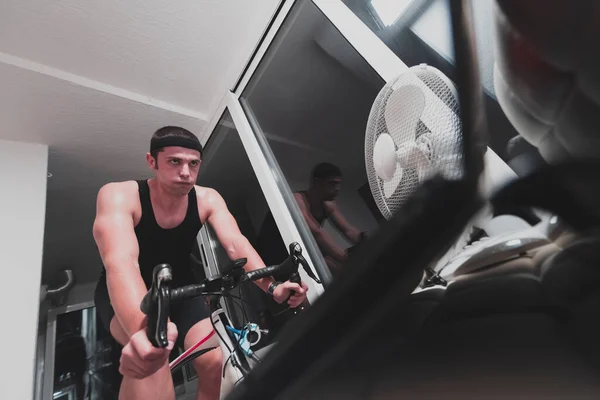 Homem Bicicleta Treinador Máquina Que Ele Está Exercitando Casa Noite — Fotografia de Stock