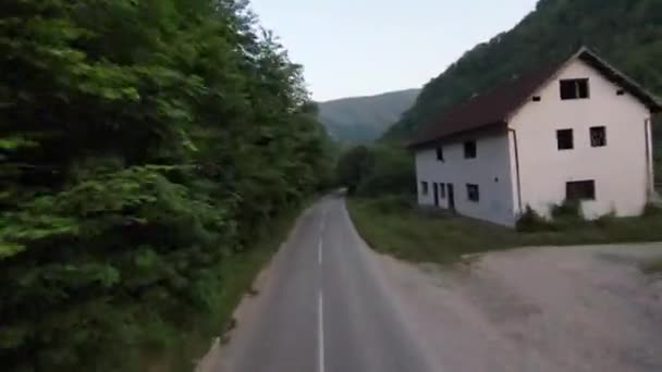 Fliegende fpv Luftaufnahme über einer Landstraße im nebligen Wald im Gebirge. — Stockvideo