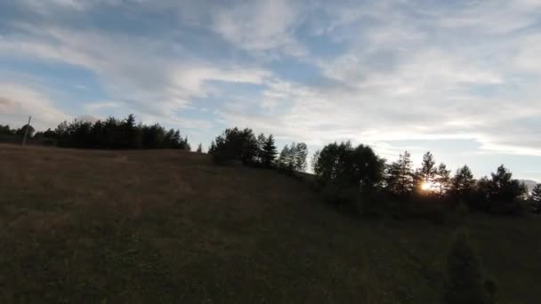 Luchtfoto hoge snelheid sport fpv drone vliegen over natuurlijke berg klif omgeven Verbazingwekkende natuur rotsachtig terrein met groene vegetatie bij zonsondergang of zonsopgang. — Stockvideo