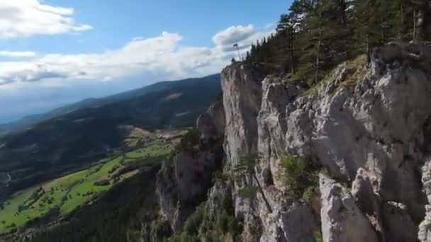 하늘에서 빠른 속도로 날아가는 공중 영화를 찍은 fpv 드론 이 구름낀 날푸른 초목 과 숲으로 둘러싸인 놀라운 자연 암석 지대를 둘러싸고 있습니다.. — 비디오