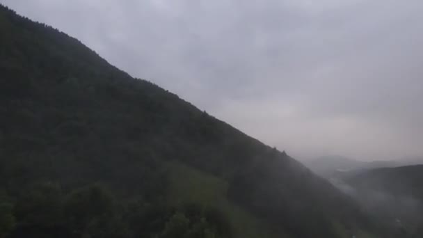 Vuelo cercano extremo sobre las copas de los árboles en la mañana brumosa del bosque. Aerial shot on fpv sport drone over clouds nature valley landscape with mountain hilly terrain. Vista cinematográfica dinámica. — Vídeos de Stock